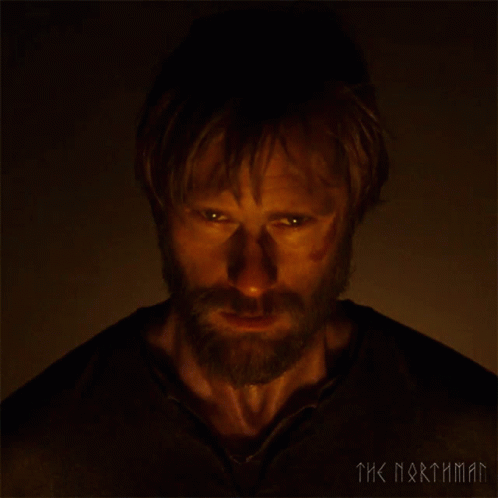A Man With A Beard Is Looking At The Camera With The Words The Northman Behind Him GIF