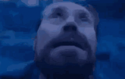 A Man With A Beard Is Looking Up At Something GIF