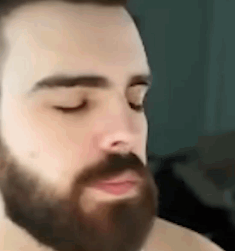 A Man With A Beard Is Making A Funny Face . GIF