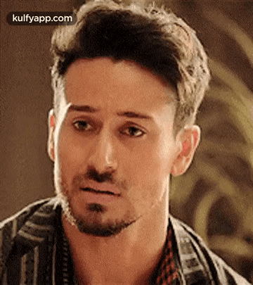 A Man With A Beard Is Making A Funny Face And Looking At The Camera . GIF
