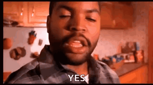 A Man With A Beard Is Making A Funny Face And Saying Yes In A Kitchen . GIF