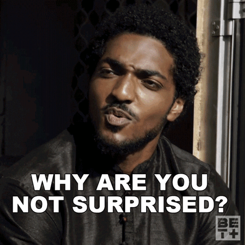 a man with a beard is making a funny face and says " why are you not surprised "