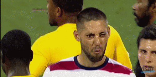A Man With A Beard Is Making A Funny Face In Front Of A Group Of Soccer Players GIF