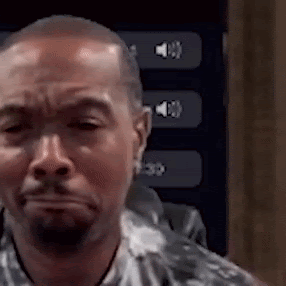 A Man With A Beard Is Making A Funny Face In Front Of A Screen With Buttons On It . GIF