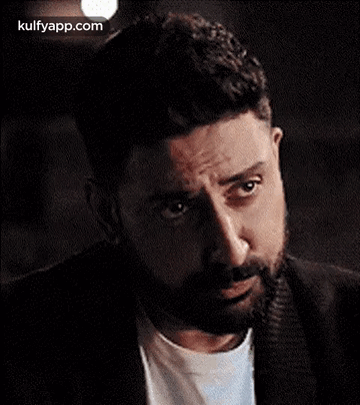 A Man With A Beard Is Making A Funny Face While Looking At The Camera . GIF