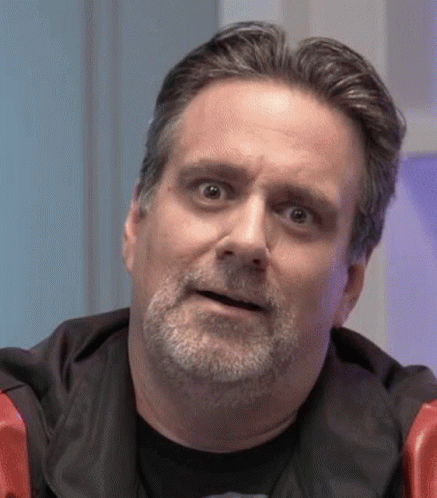 A Man With A Beard Is Making A Funny Face While Looking At The Camera . GIF