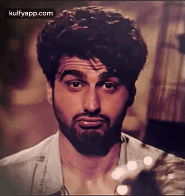 A Man With A Beard Is Making A Funny Face While Looking At The Camera . GIF