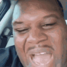 A Man With A Beard Is Making A Funny Face While Sitting In The Driver 'S Seat Of A Car . GIF