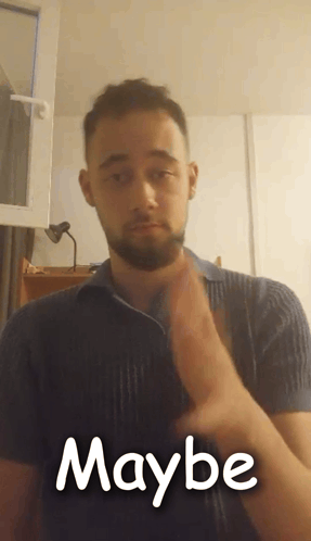 A Man With A Beard Is Making A Maybe Sign With His Hands GIF