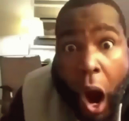 A Man With A Beard Is Making A Surprised Face With His Mouth Open . GIF