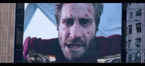 A Man With A Beard Is On A Large Screen GIF