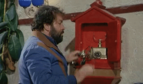 A Man With A Beard Is Opening A Red Mailbox With A Screwdriver . GIF