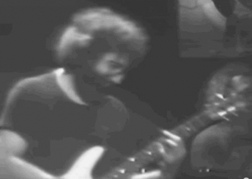 A Man With A Beard Is Playing A Guitar GIF