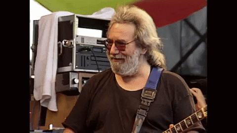 A Man With A Beard Is Playing A Guitar With A Blue Strap GIF