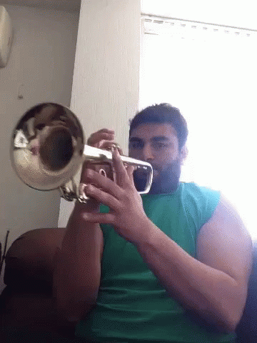 A Man With A Beard Is Playing A Trumpet GIF