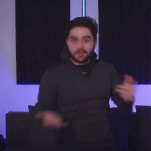 A Man With A Beard Is Pointing His Finger At The Camera . GIF