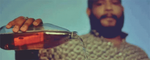 A Man With A Beard Is Pouring Soda Into A Glass GIF