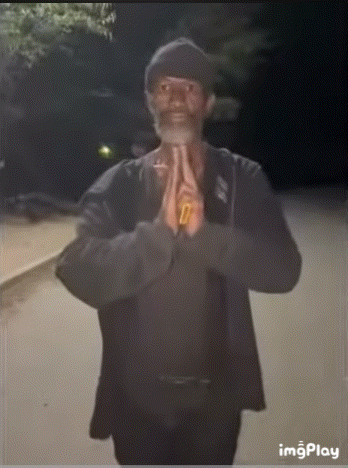 A Man With A Beard Is Praying With His Hands Folded In Front Of His Face GIF