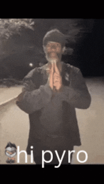 A Man With A Beard Is Praying With The Words " Hi Pyro " Behind Him GIF