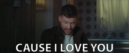 A Man With A Beard Is Singing In A Dark Room And The Words `` Cause I Love You '' Are Behind Him . GIF