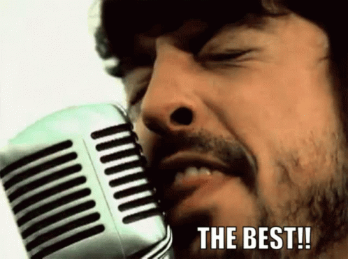 A Man With A Beard Is Singing Into A Microphone With The Words " The Best " Written Below Him GIF