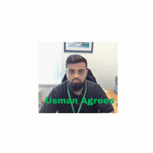 A Man With A Beard Is Sitting At A Desk With Usman Agrees Written On The Bottom GIF