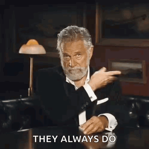 A Man With A Beard Is Sitting At A Table And Making A Funny Face . GIF