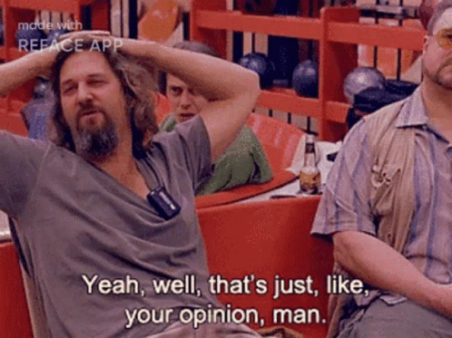 A Man With A Beard Is Sitting At A Table In A Bowling Alley With His Hands On His Head . GIF