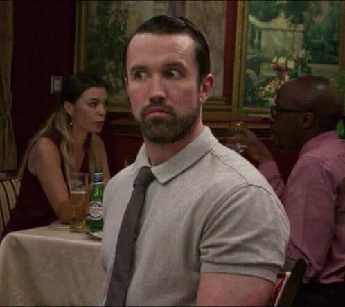 A Man With A Beard Is Sitting At A Table With A Woman GIF