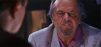 A Man With A Beard Is Sitting At A Table With Another Man . GIF
