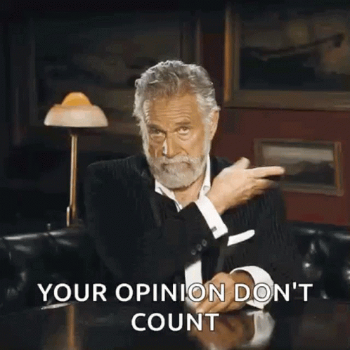 A Man With A Beard Is Sitting At A Table With His Hands In The Air And The Words Your Opinion Do N't Count GIF