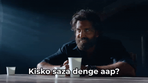 A Man With A Beard Is Sitting At A Table With Two Cups Of Coffee And The Caption Kisko Saza Denge Aap GIF