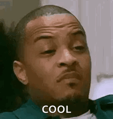 A Man With A Beard Is Sitting Down And Making A Funny Face . GIF