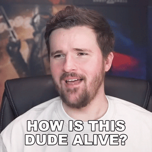 A Man With A Beard Is Sitting In A Chair And Says How Is This Dude Alive GIF