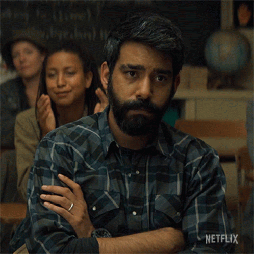 A Man With A Beard Is Sitting In A Classroom With Netflix Written On The Bottom Of The Image GIF