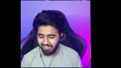 A Man With A Beard Is Sitting In A Gaming Chair With Headphones On . GIF