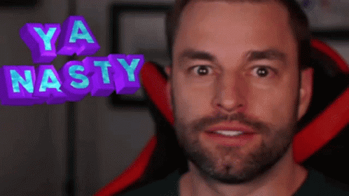 A Man With A Beard Is Sitting In A Red Chair With The Words Ya Nasty Above His Head GIF