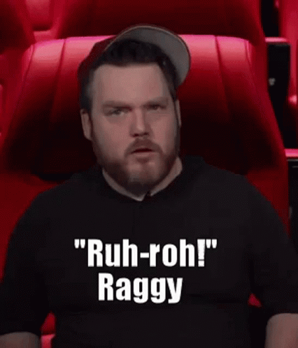 A Man With A Beard Is Sitting In A Theater Watching A Movie And Making A Funny Face . GIF