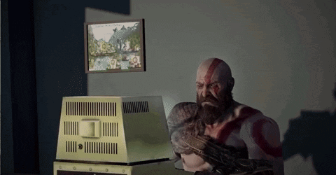 A Man With A Beard Is Sitting In Front Of A Computer Monitor GIF