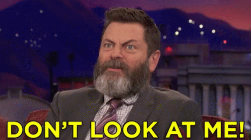 A Man With A Beard Is Sitting In Front Of A Sign That Says " Do N't Look At Me " GIF