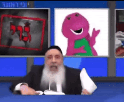 A Man With A Beard Is Sitting In Front Of A Television With A Picture Of Barney On The Screen . GIF