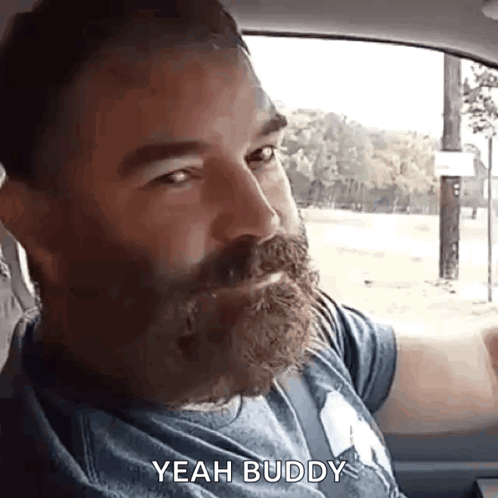 A Man With A Beard Is Sitting In The Back Seat Of A Car And Saying Yeah Buddy . GIF