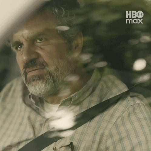 A Man With A Beard Is Sitting In The Back Seat Of A Car With A Hbo Max Logo Behind Him GIF