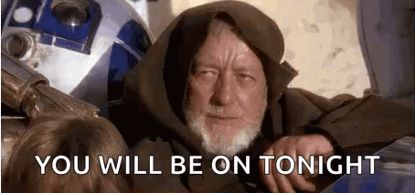 A Man With A Beard Is Sitting Next To A Robot . GIF