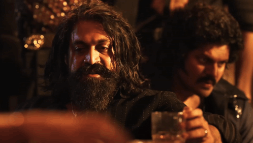 A Man With A Beard Is Sitting Next To Another Man With The Words Absolute Cinema Below Him GIF