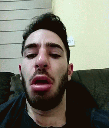 A Man With A Beard Is Sitting On A Couch And Making A Funny Face GIF