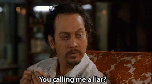 A Man With A Beard Is Sitting On A Couch And Saying You Calling Me A Liar . GIF