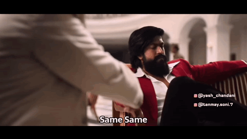 A Man With A Beard Is Sitting On A Couch With Another Man And Talking To Him . GIF