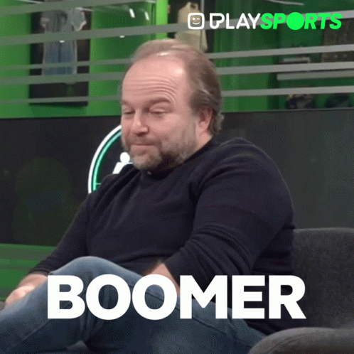 A Man With A Beard Is Sitting On A Couch With The Word Boomer Written On The Bottom GIF
