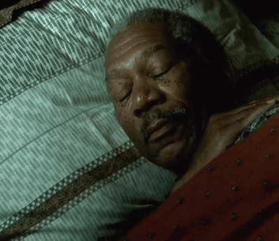 A Man With A Beard Is Sleeping In A Bed GIF